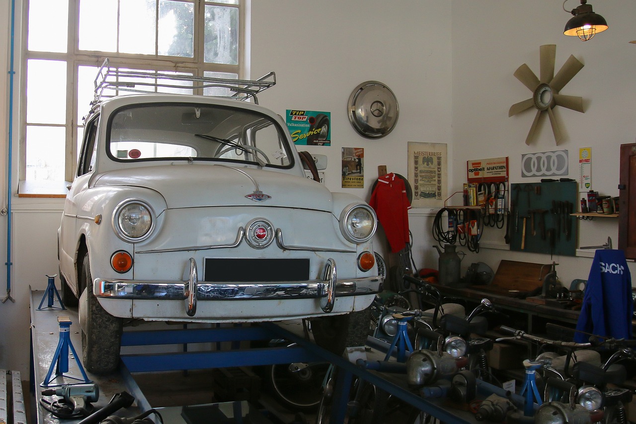 Small car raised on a lift in an auto repair shop